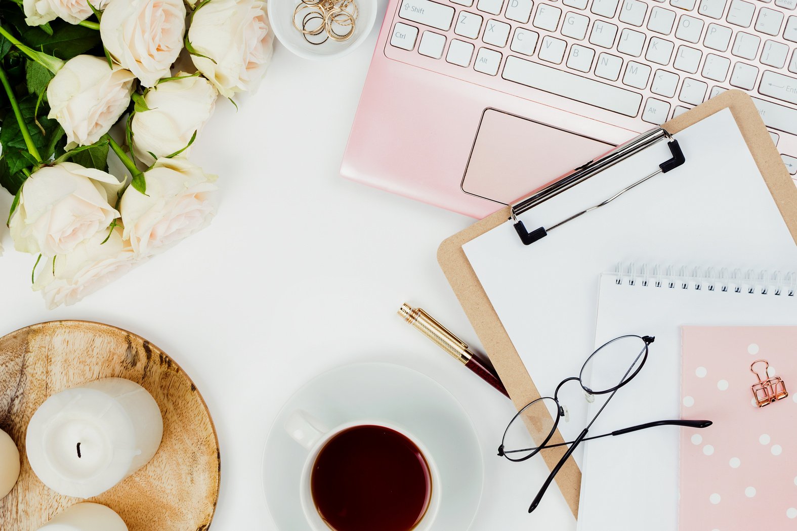 Stylish flatlay frame arrangement with pink laptop, tea, roses, glasses and other accessories on white. Feminine business mockup